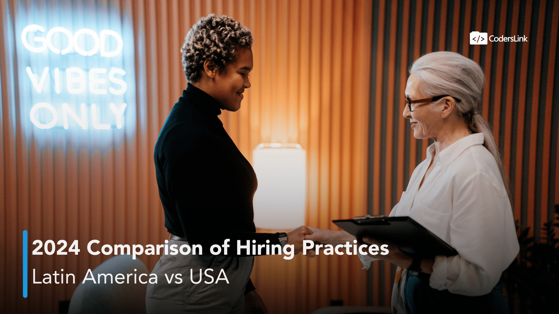 Two people, one with curly hair and another with long, gray hair, shake hands smiling in an office adorned with a "Good Vibes Only" sign. The text reads: "2024 Comparison of Hiring Practices: Latin America vs USA." CodersLink logo is in the top right corner. CodersLink 2024.