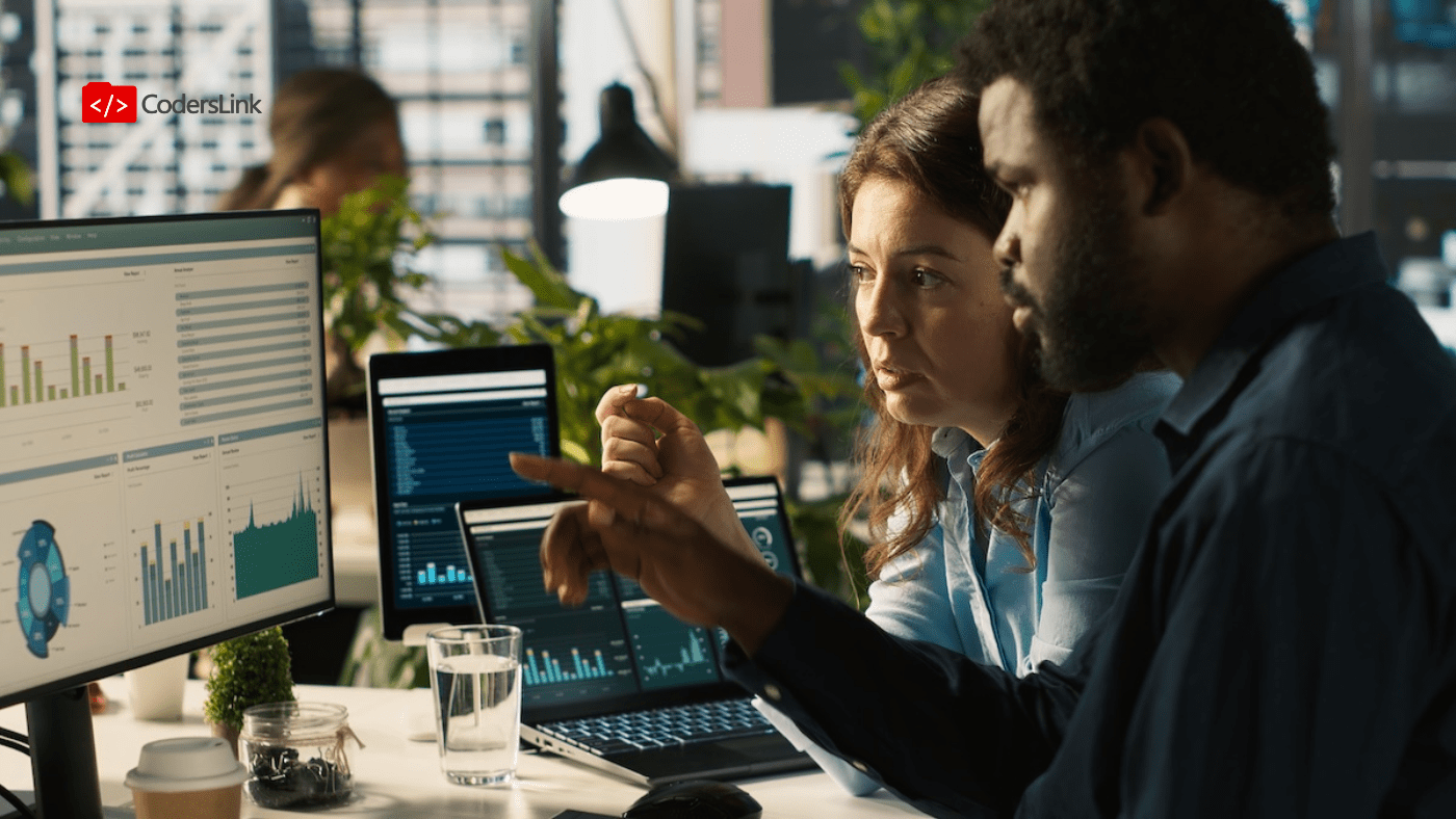 A fintech engineering team leader and developer in a synchronized sprint session, analyzing data security and compliance dashboards on a computer screen.